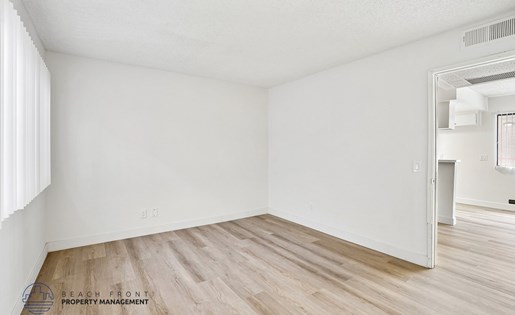 A room with wooden flooring and white walls.